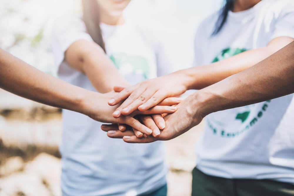 Close up of people volunteer teamwork putting finger on star shapehands