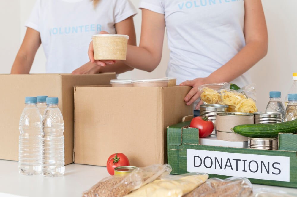 Volunteers filling box with food for donation